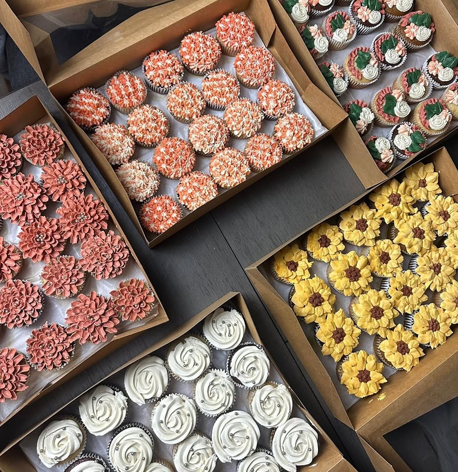 Assorted floral cupcakes in seasonal colours