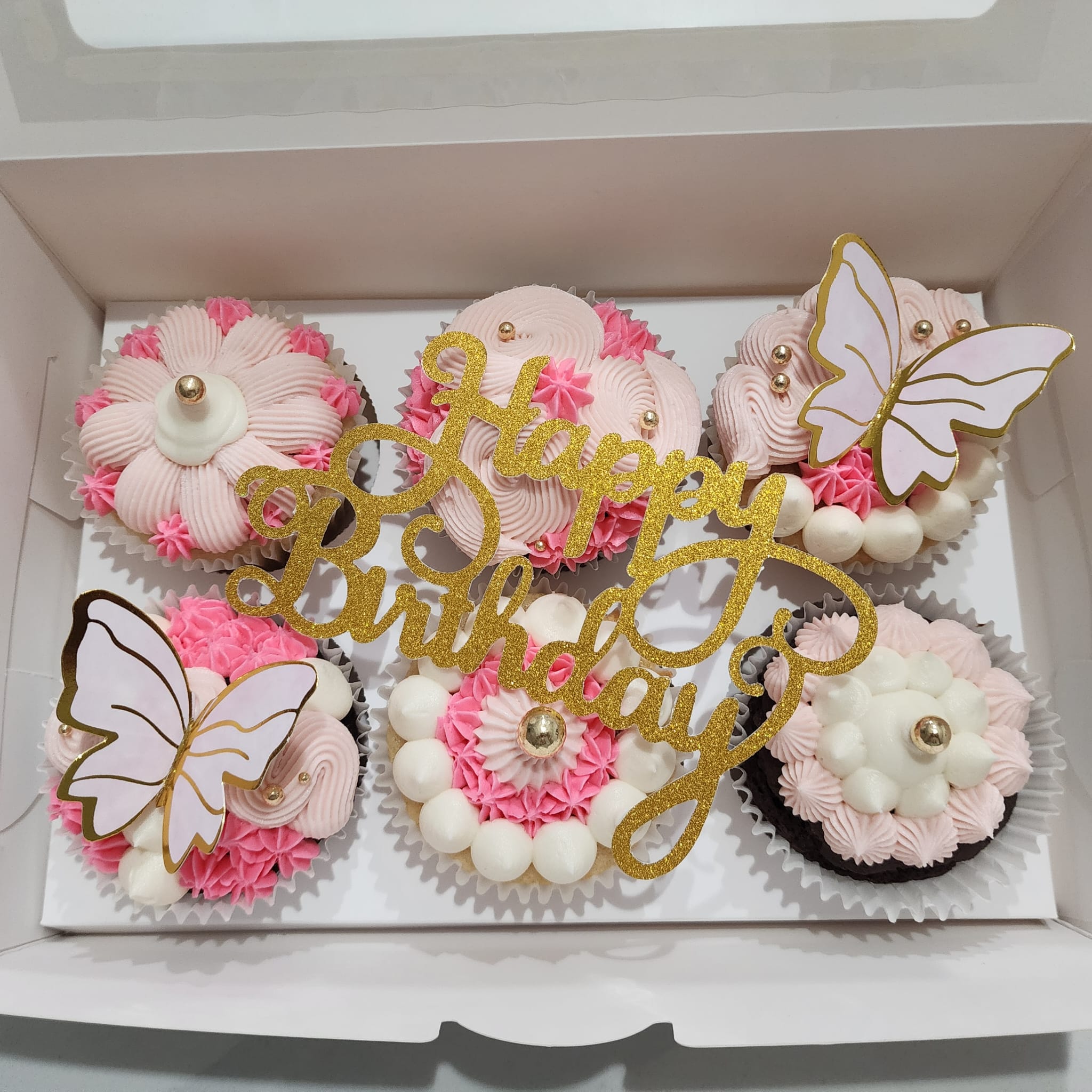 Pink birthday cupcakes with flowers and butterflies