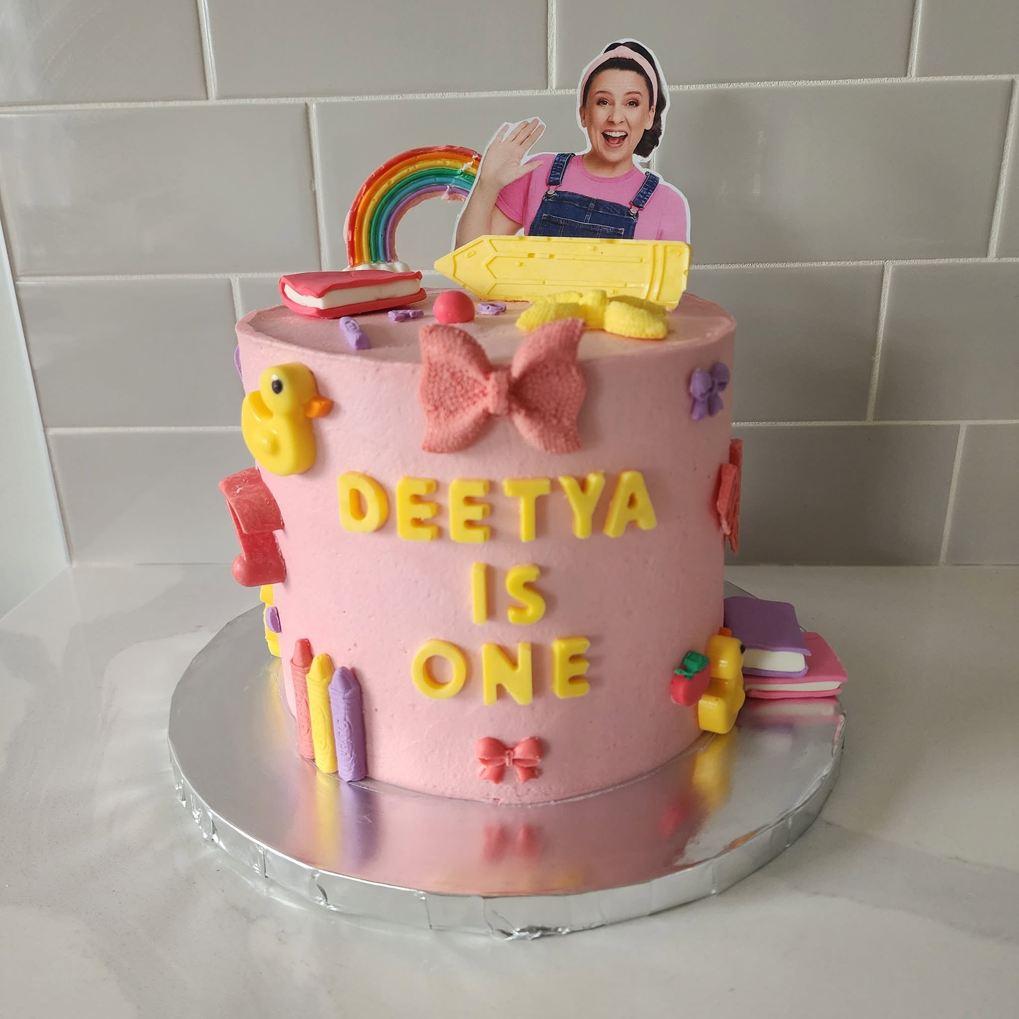 Pink first birthday cake with colourful decorations